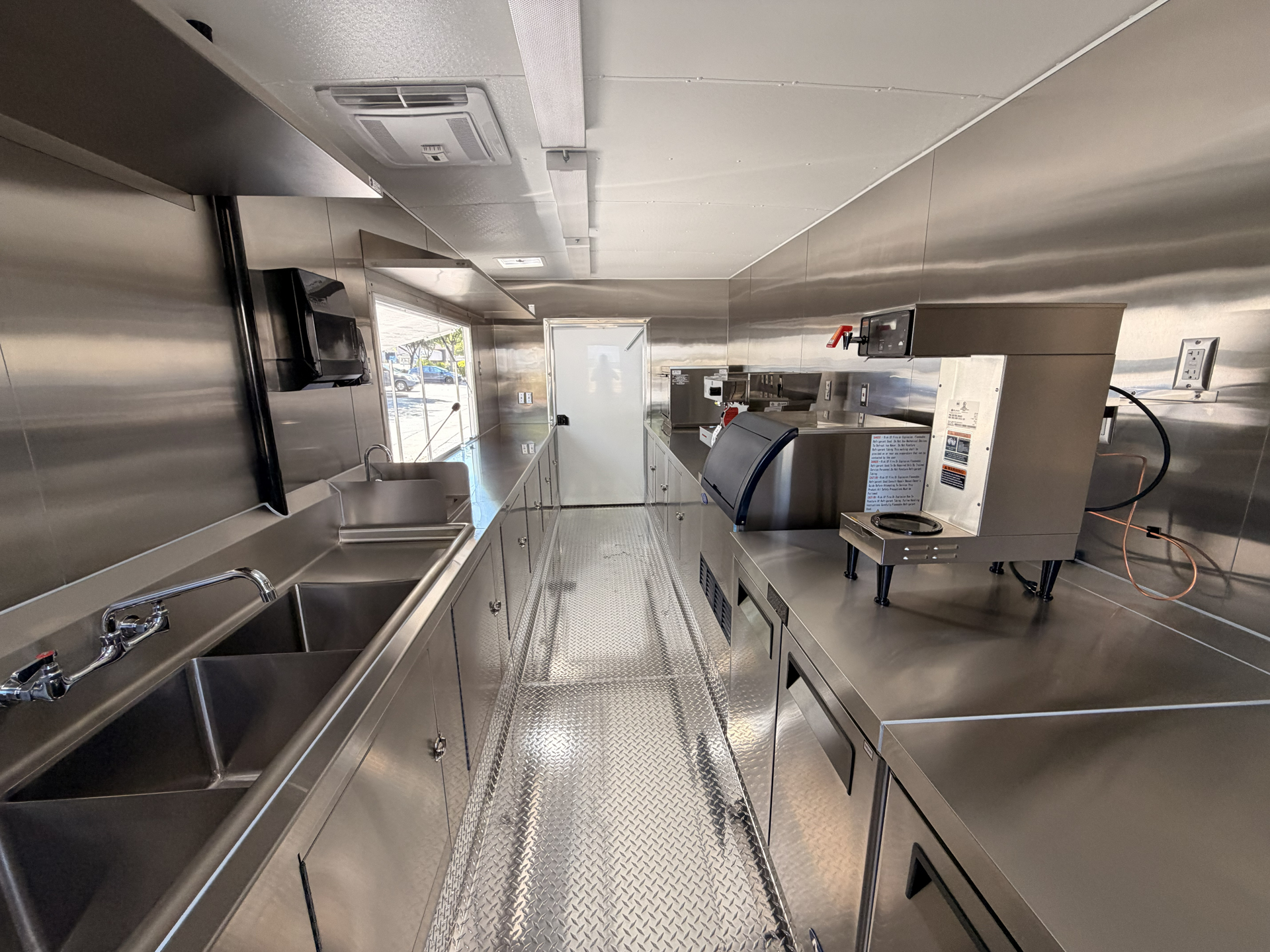 Coffee trailer interior layout with stainless steel sinks, preparation counters, and commercial equipment