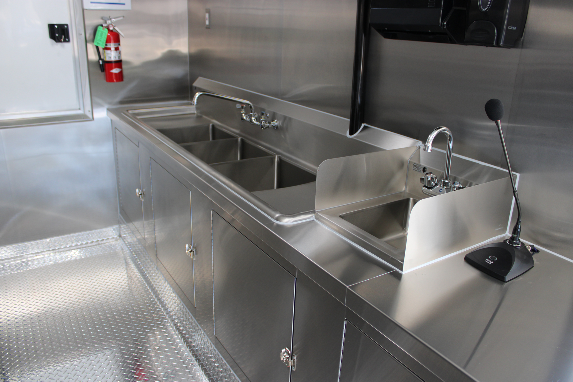 Three-compartment sink and separate handwashing sink inside a commercial coffee trailer