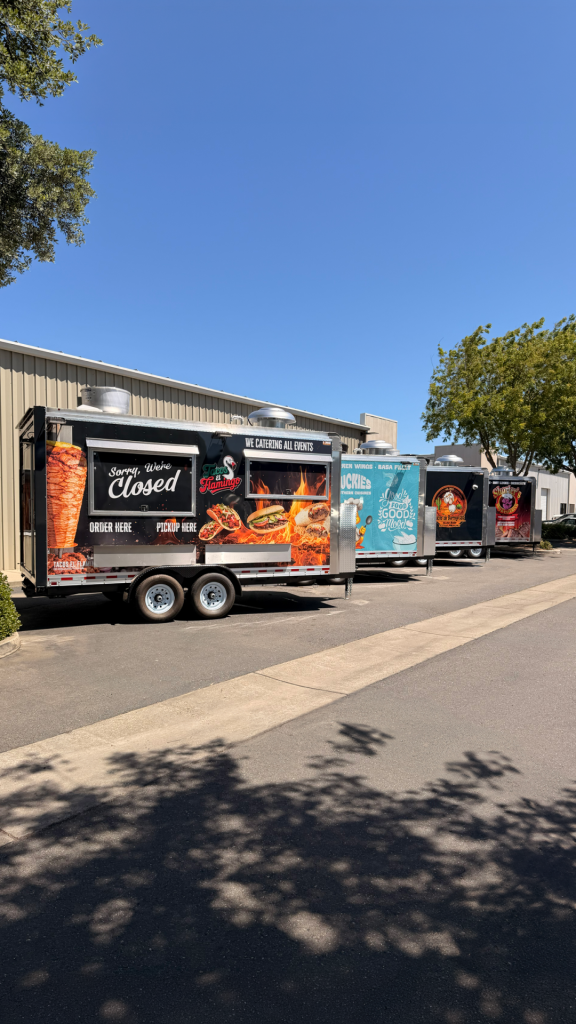 Custom food trailers for sale with branded exterior wraps, service windows, tandem axles, and rooftop ventilation.