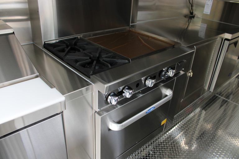 Commercial combination gas range inside the custom 16ft coffee food trailer built by Golden State Trailers.