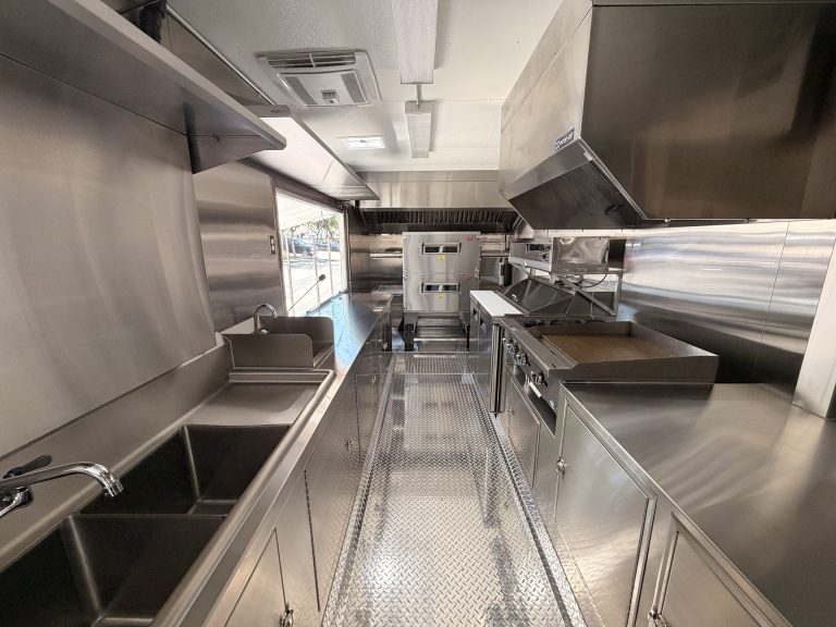 mobile pizza kitchen interior with stainless steel prep counters, cooking equipment, ventilation hoods, and service area