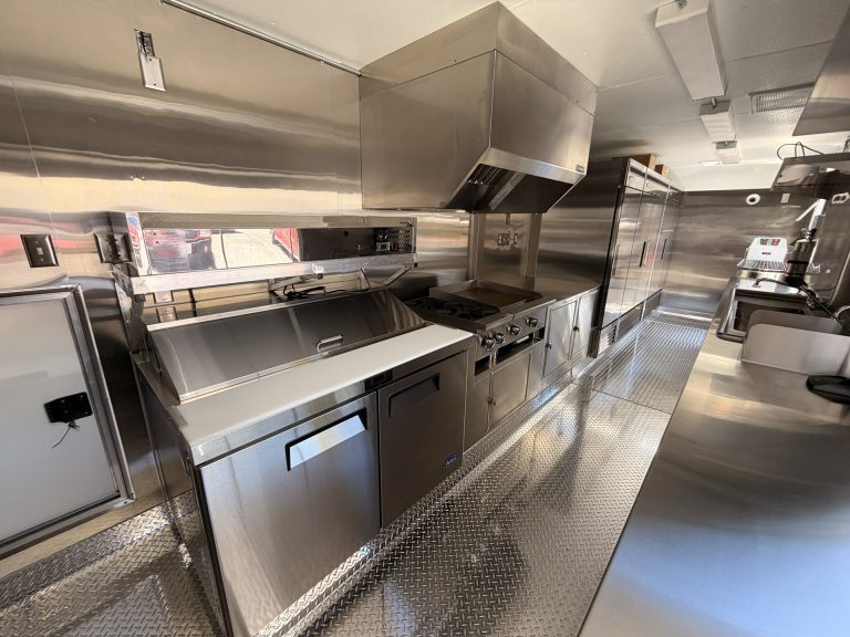 custom pizza food trailer interior with commercial cooking line, stainless steel surfaces, and ventilation