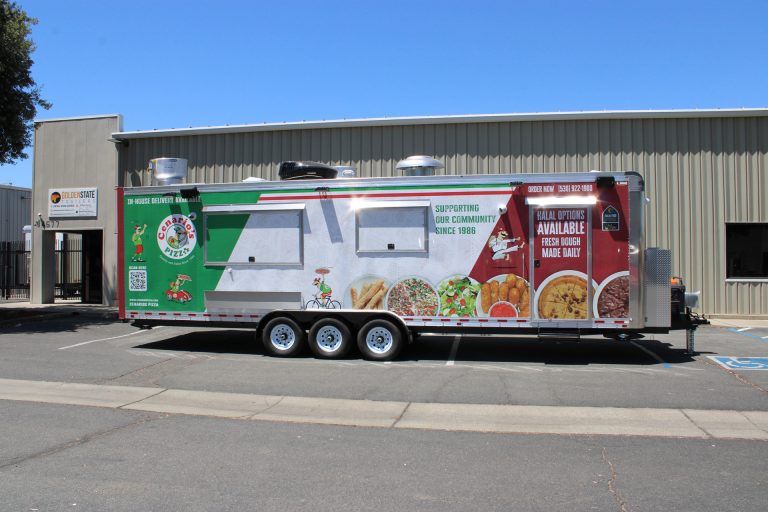 pizza kitchen trailer service side with concession windows, custom wrap graphics, and exterior customer service area