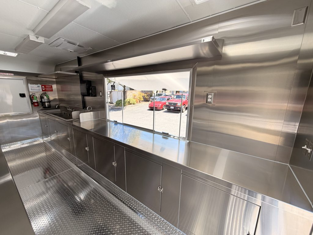 Service window and stainless steel handoff counter inside the Reef-Sunset school food trailer