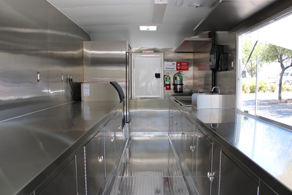 School food trailer interior with stainless steel preparation counters, sinks, and storage