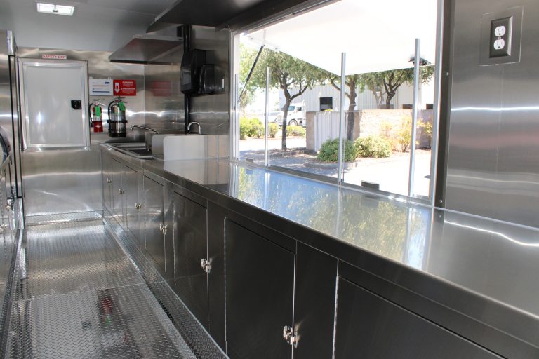 Large service window above a stainless steel counter inside the Avenal High School food trailer