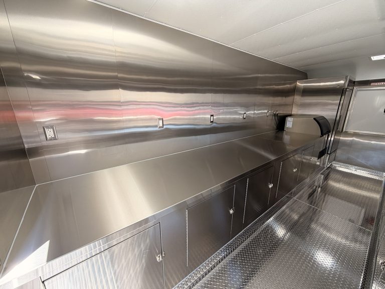 Stainless steel preparation counter and wall outlets inside the Avenal High School food trailer